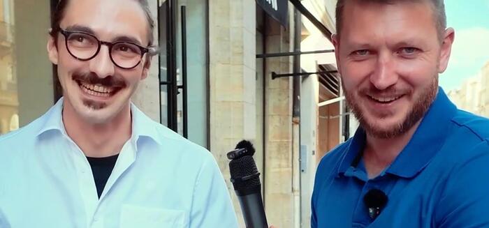 Deux personnes souriantes dans une rue de Bordeaux, pendant le tournage.